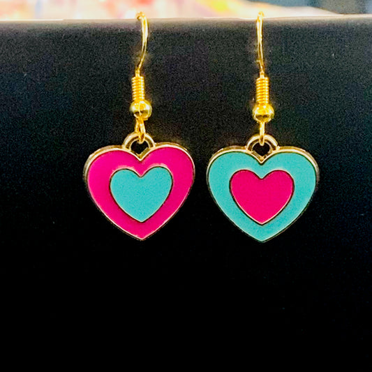 Heart-shaped earrings with pink and teal hearts and gold hardware on a black background